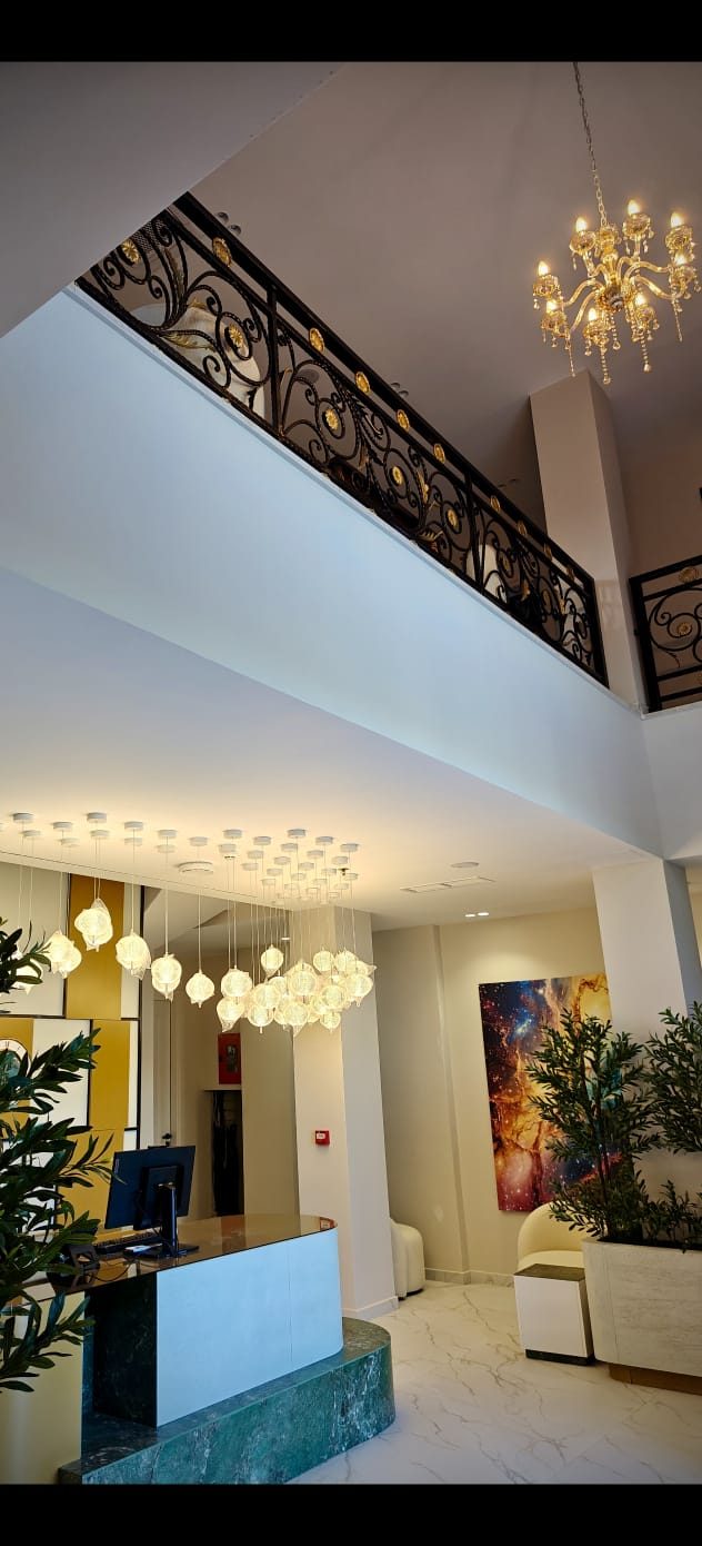 Hall principale — scala in ferro battuto e lampadari dorati